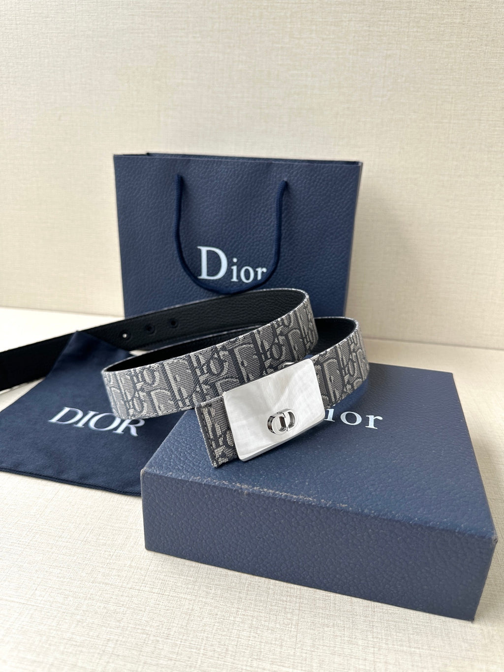 Dior belt with gray monogram strap and white/silver-toned buckle in front view