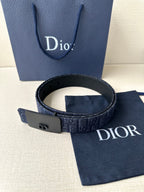 Dior belt with black buckle and navy logo-pattern strap, shown coiled