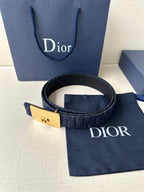 Dior belt with navy patterned strap and gold-tone buckle plaque, strap end with holes.