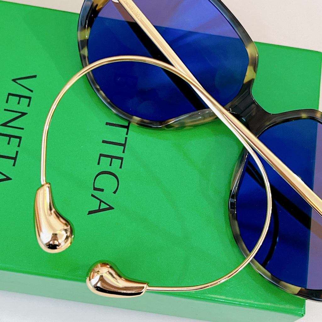 Sunglasses close-up with gold temples and mirrored blue lenses