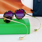 Sunglasses with tortoiseshell frames and purple lenses, slim gold temples