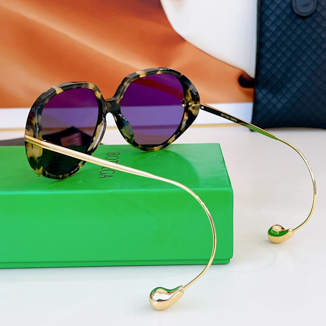 Sunglasses with tortoiseshell frames and purple lenses, slim gold temples