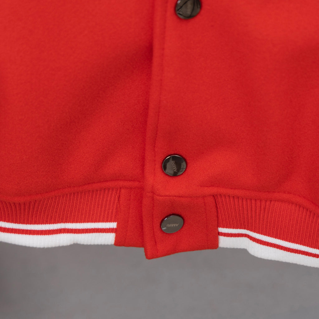 Red varsity jacket hem with ribbed striped trim and front snap buttons