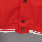 Red varsity jacket hem with ribbed striped trim and front snap buttons