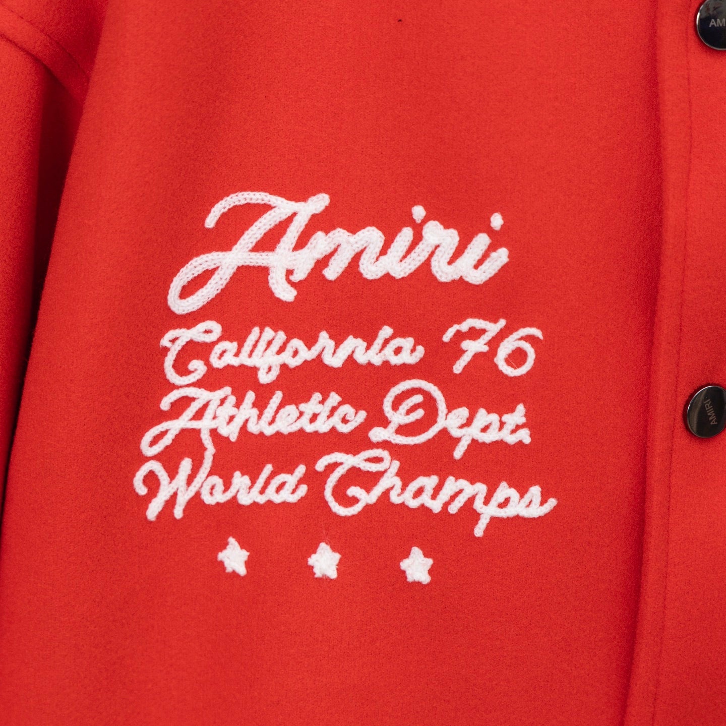 Red varsity jacket chest embroidery with cursive text and small star accents