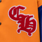 Orange varsity jacket sleeve close-up with red raised letter logo and white outline