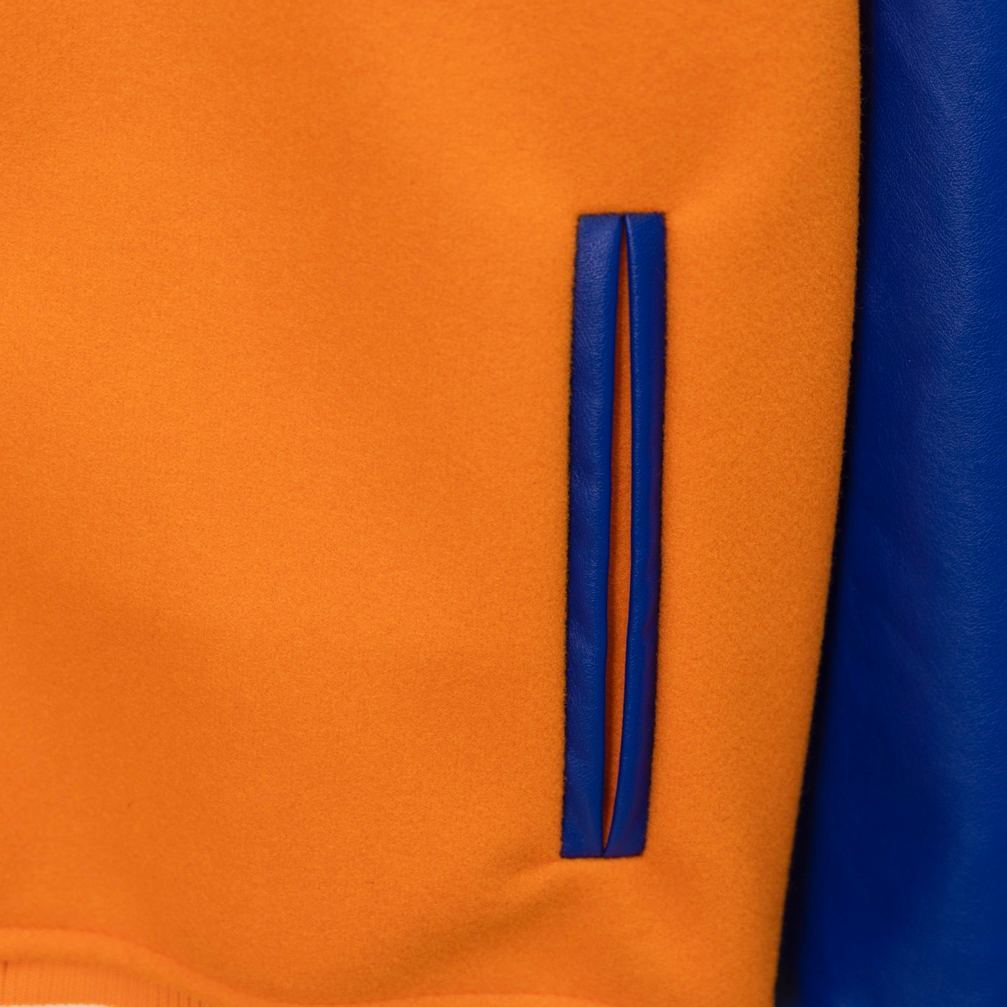 Orange varsity jacket sleeve stripe panel with blue trim and curved edge detail