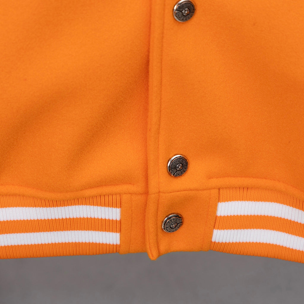 Orange varsity jacket front with snap buttons and white striped ribbed cuffs