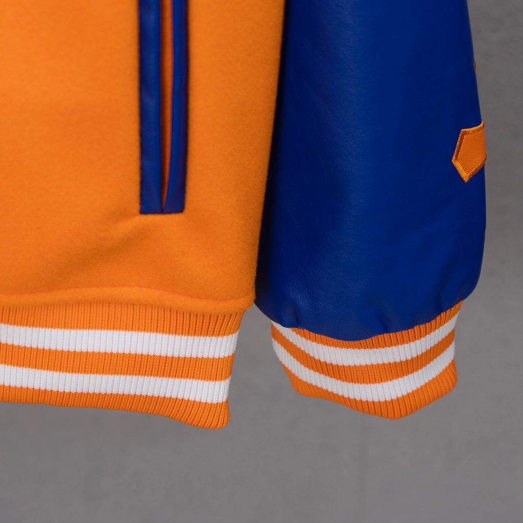 Orange and blue varsity jacket sleeve and hem with striped ribbed cuffs
