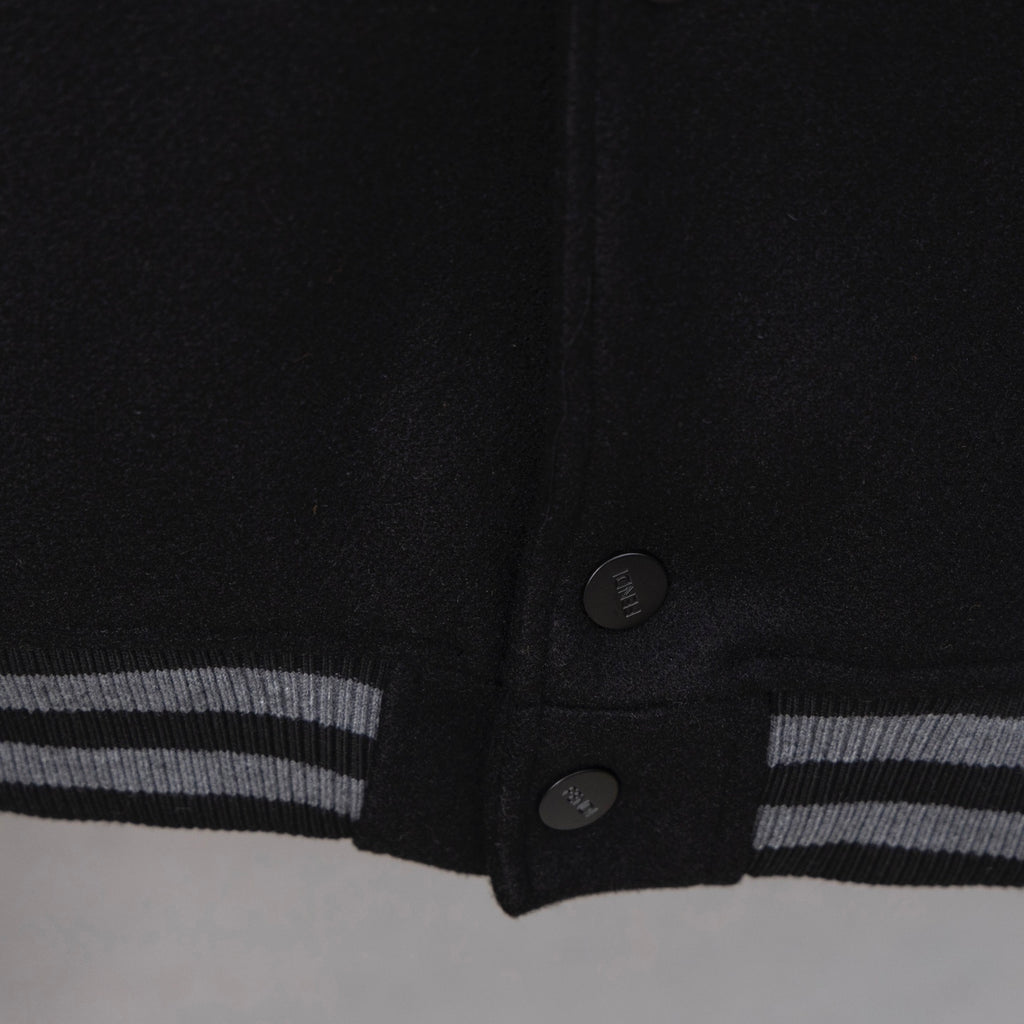 Black jacket hem with snap buttons and striped ribbed cuff