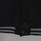 Black jacket hem with snap buttons and striped ribbed cuff