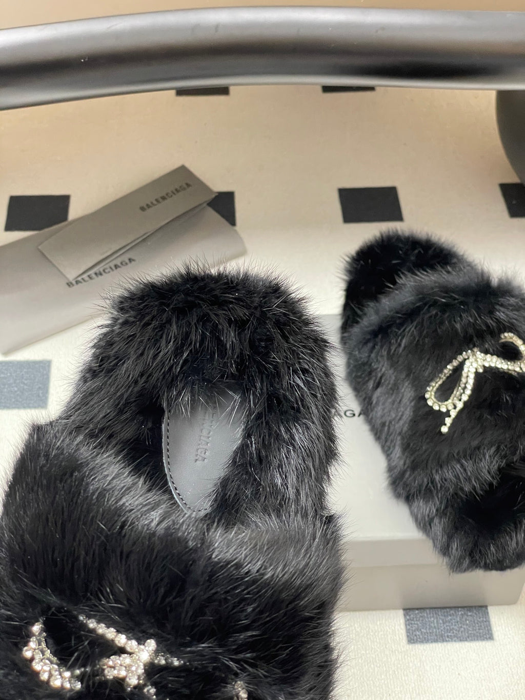 Black plush sandals with crystal bow detail and curved open strap