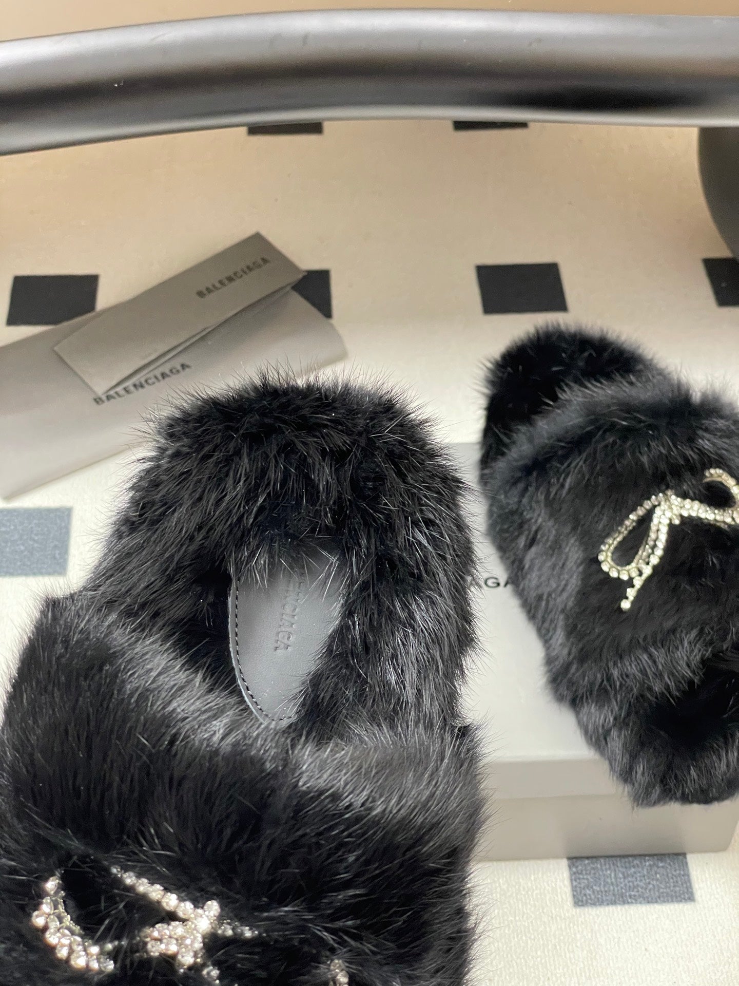 Black plush sandals with crystal bow detail and curved open strap