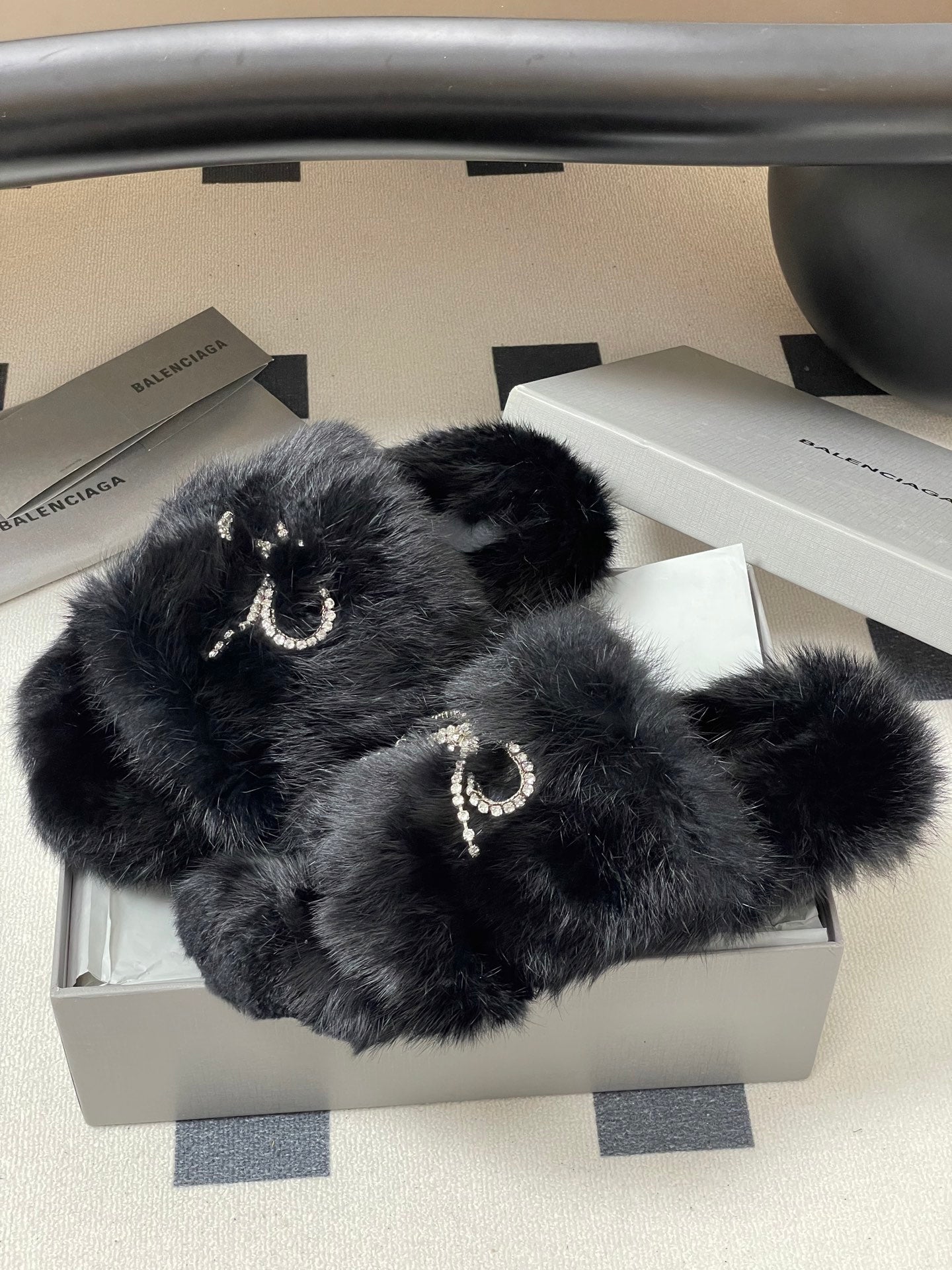 Black faux-fur slide sandals with rhinestone bow strap detail, open toe