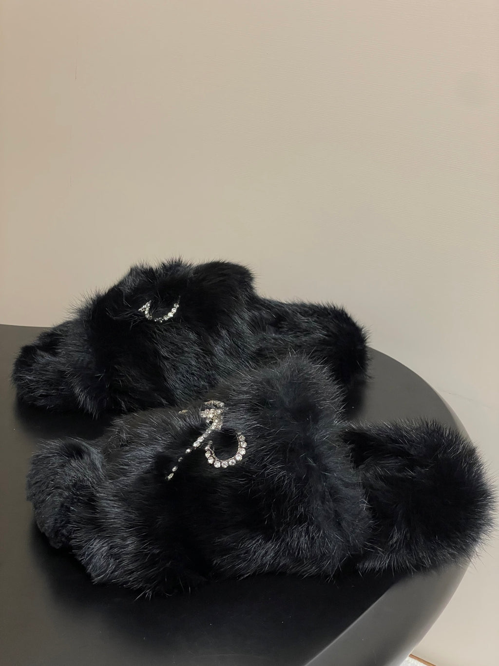 Black faux-fur slide sandals with rhinestone bow centerpiece strap