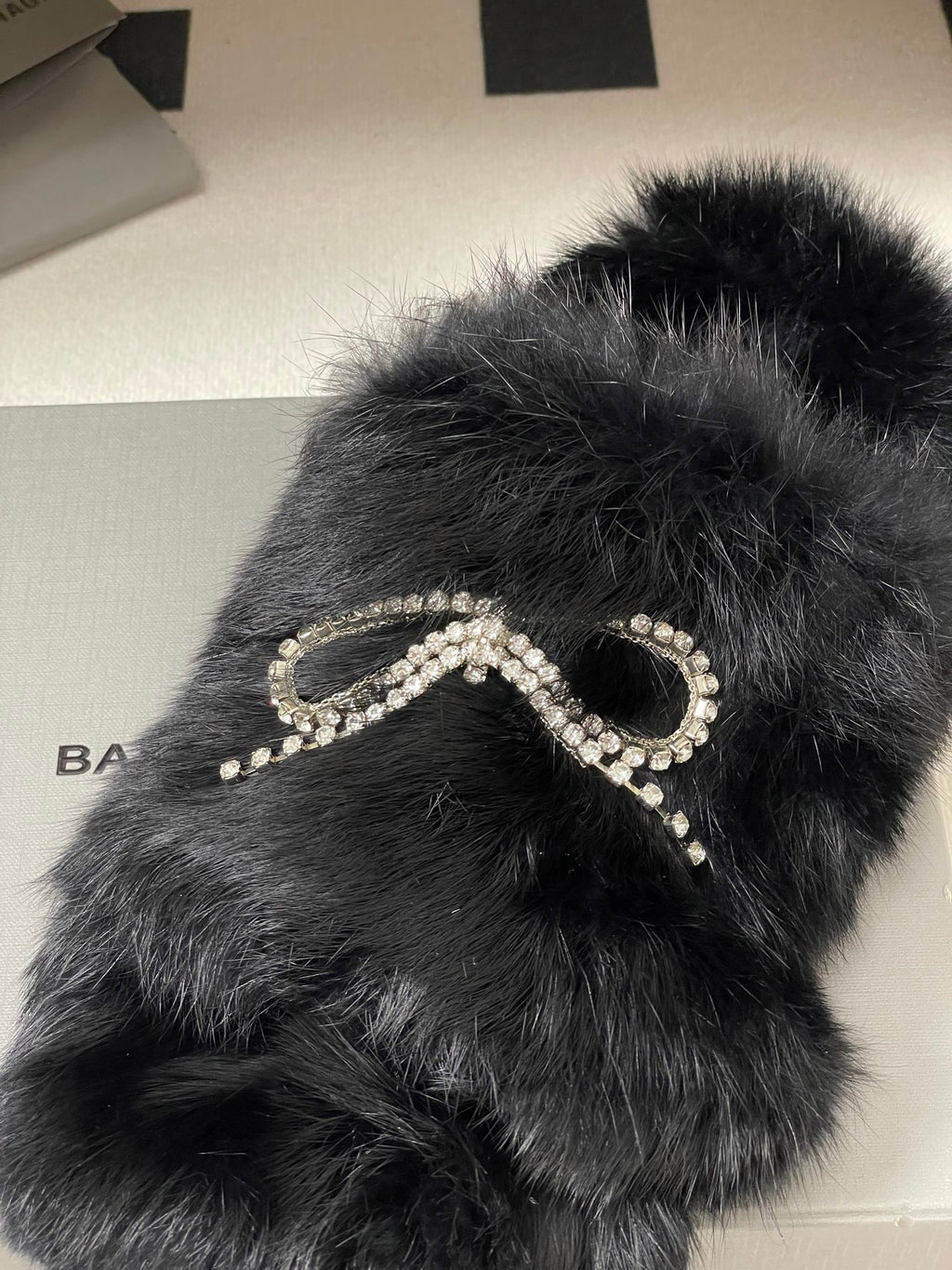 Black plush sandals close-up with crystal horseshoe-and-bead ornament strap