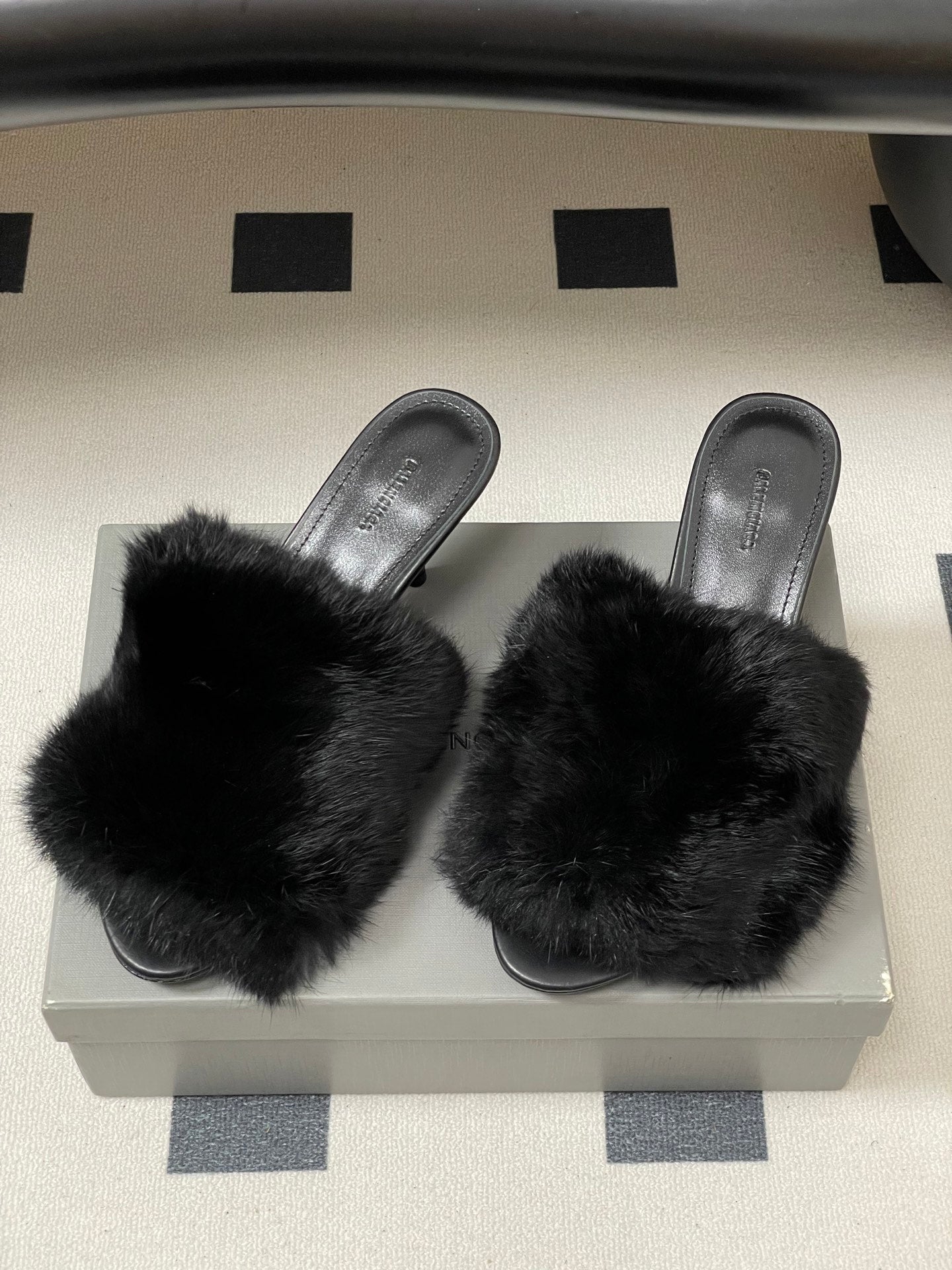 Pair of black fuzzy slide sandals with wide strap and slim heels