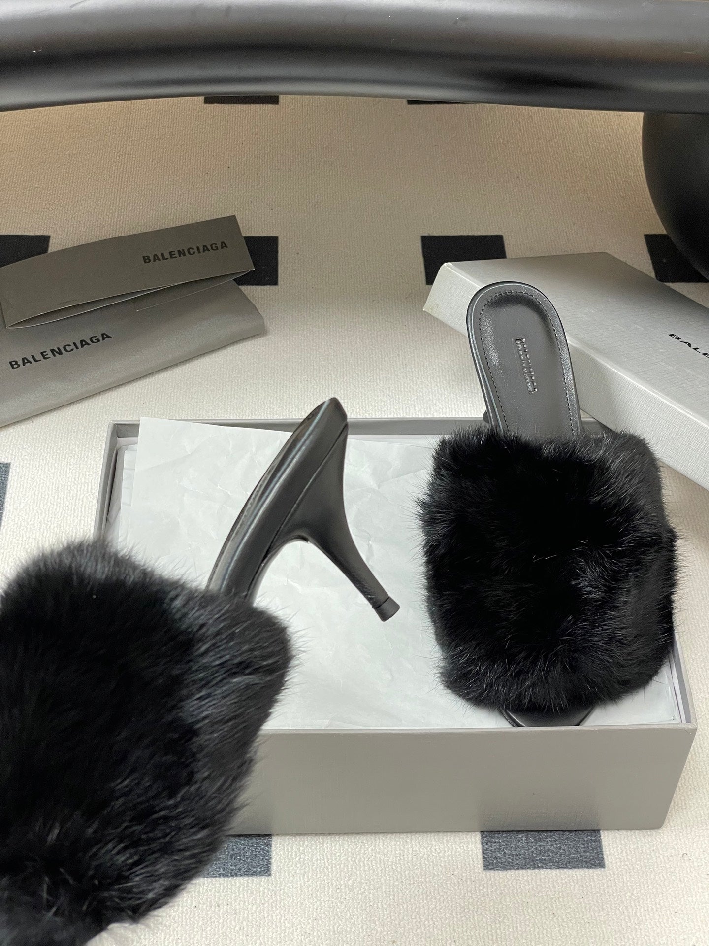 Black fur heeled sandals with open back, shown from side angle