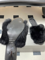 Black fur slide sandals with visible gray insoles and slip-on straps