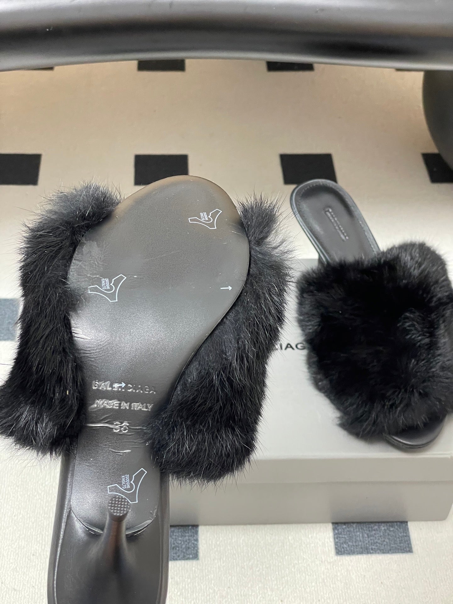 Black fur slide sandals with visible gray insoles and slip-on straps