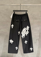 Black wide-leg pants with elastic waistband and white cross-shaped appliques.