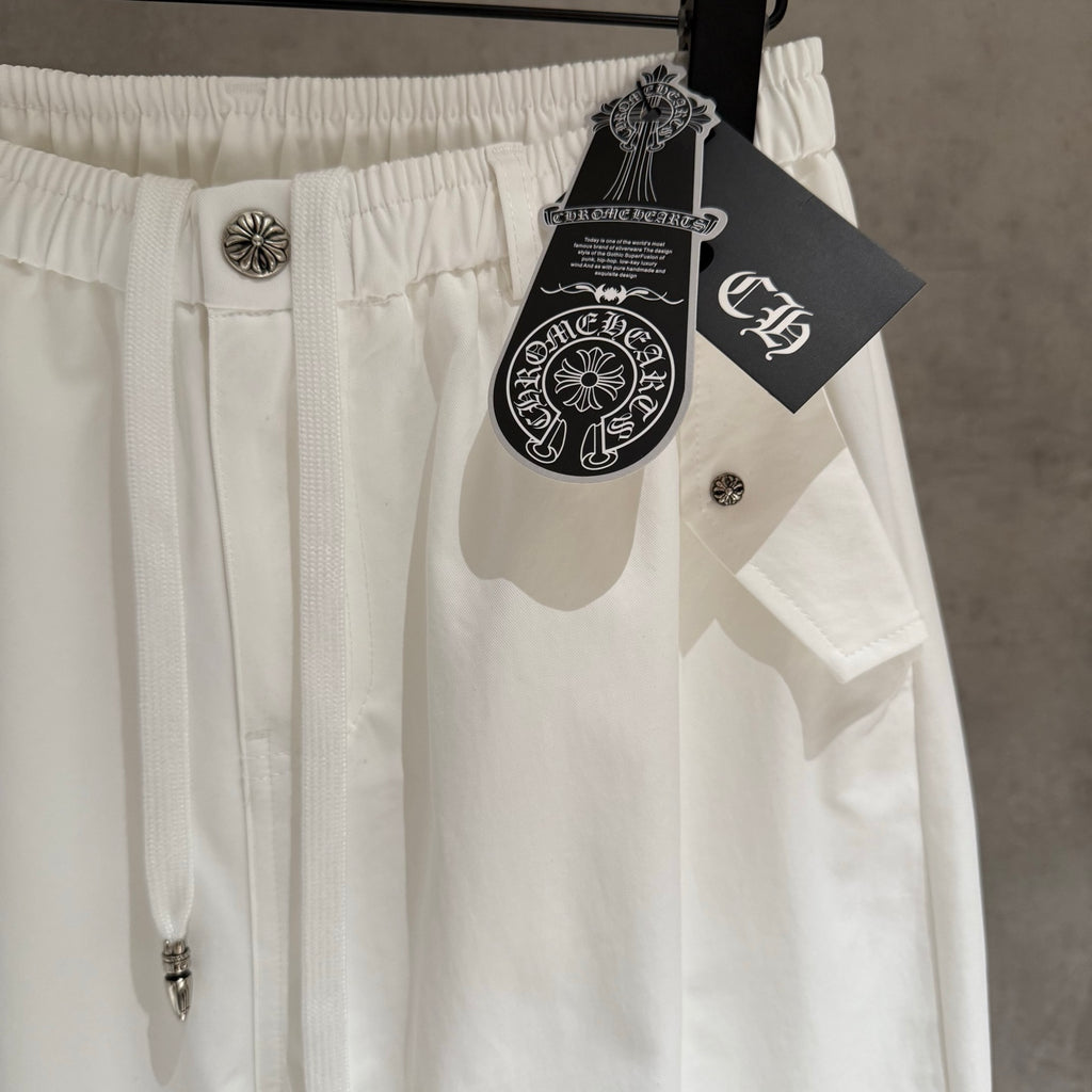 White pants with elastic waist, silver-tone button, and hanging tag charm