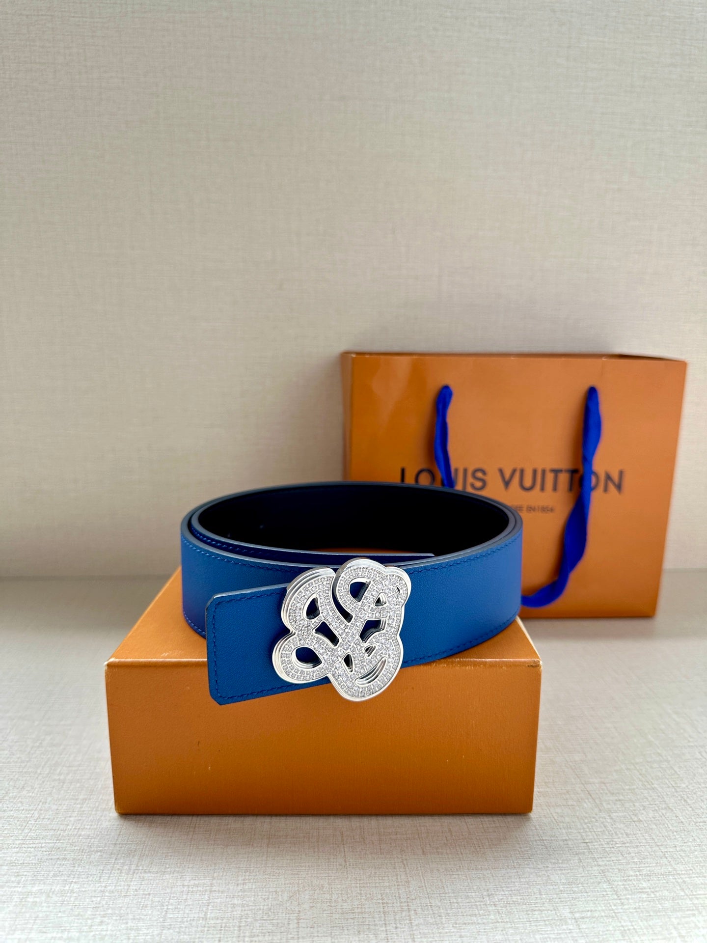 Louis Vuitton blue leather belt with gold-tone logo buckle, side view