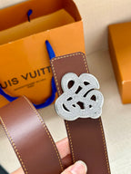 Brown leather belt with silver-tone logo buckle, close-up view