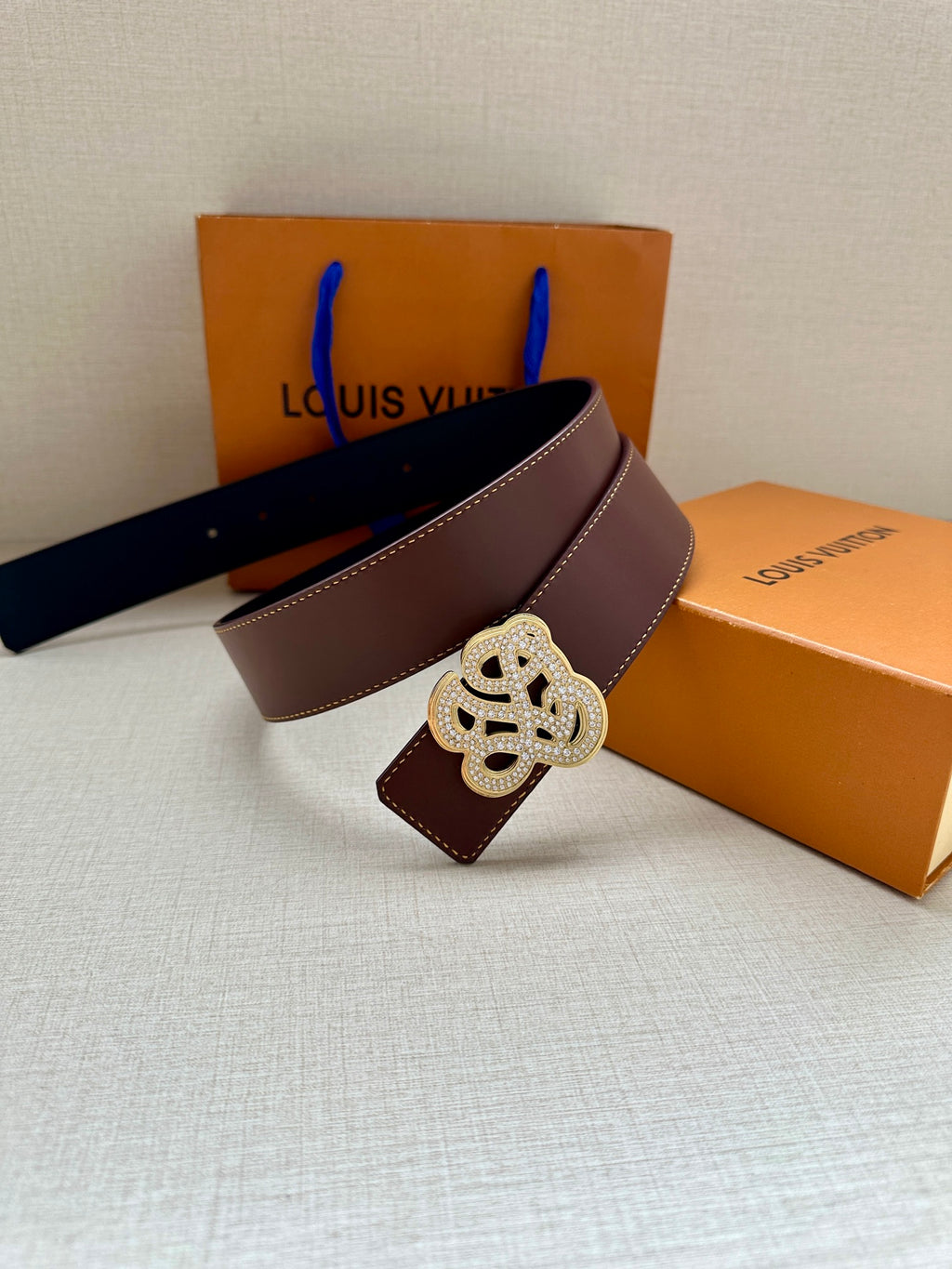 Dark brown leather belt with silver-tone logo buckle and stitched strap