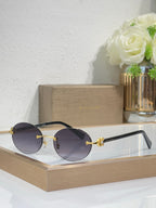 Gold-tone sunglasses with dark gray lenses and black temples, round lenses, jewel detail.
