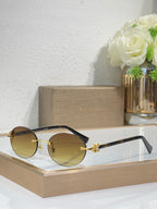 Gold-tone sunglasses with dark gray lenses and black temples, round lenses, small emblem.