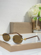 Gold-tone sunglasses with brown lenses and dark temples, round lenses, gold bar detail.