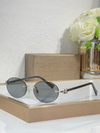 Silver-tone sunglasses with dark gray lenses and black temples, round lenses, small emblem.
