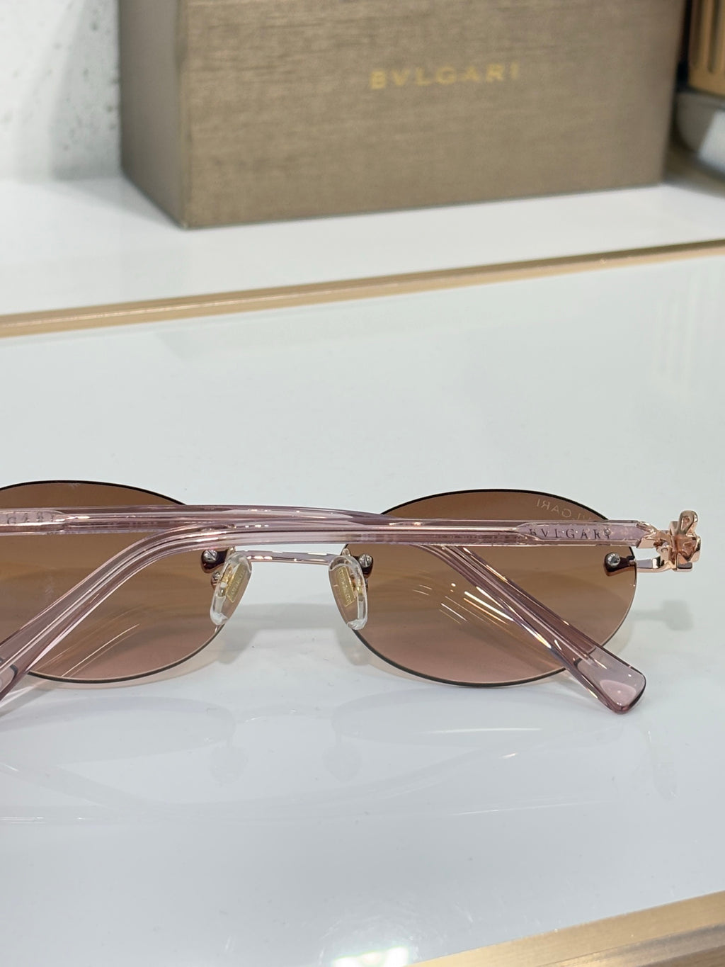 Bvlgari thin round glasses with rose-tinted lenses and gold nose bridge