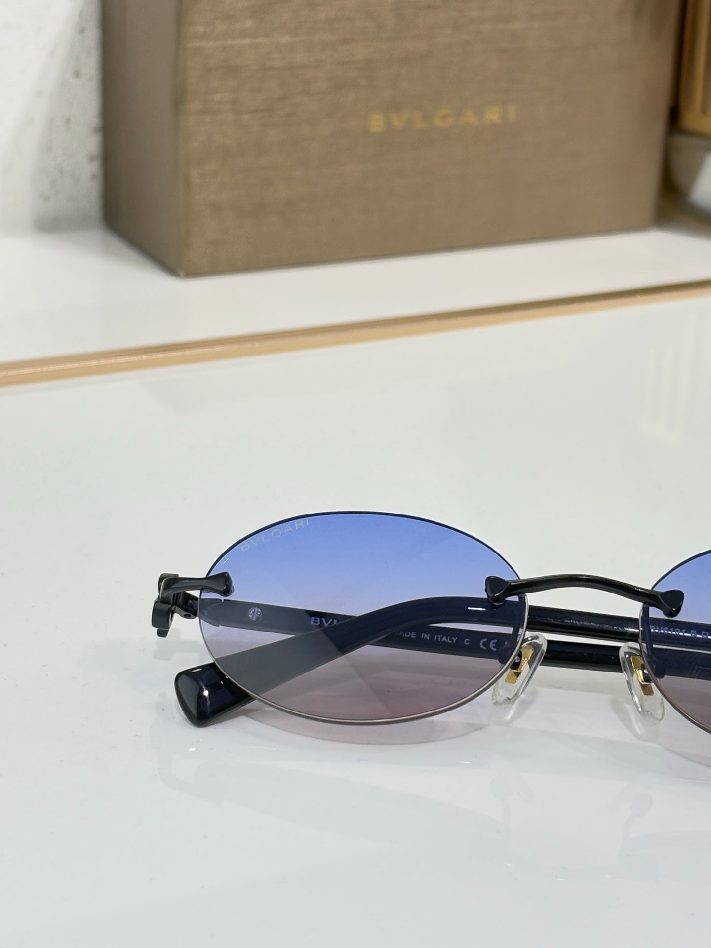 Bvlgari oval glasses with dark frames and blue-tinted lenses, gold bridge