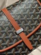 Goyard logo leather patch on tan strap over gray patterned canvas bag.