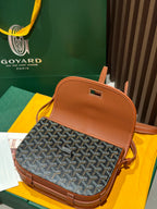 Goyard mini bag with tan top handle, gray patterned front and tan flap.