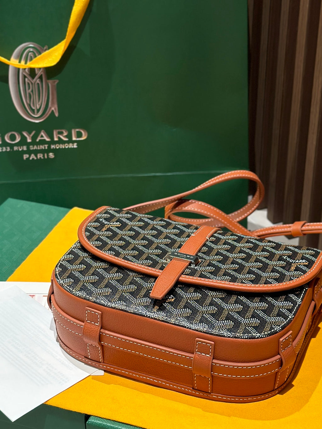 Goyard small shoulder bag with gray patterned body and tan handle, crossbody strap.