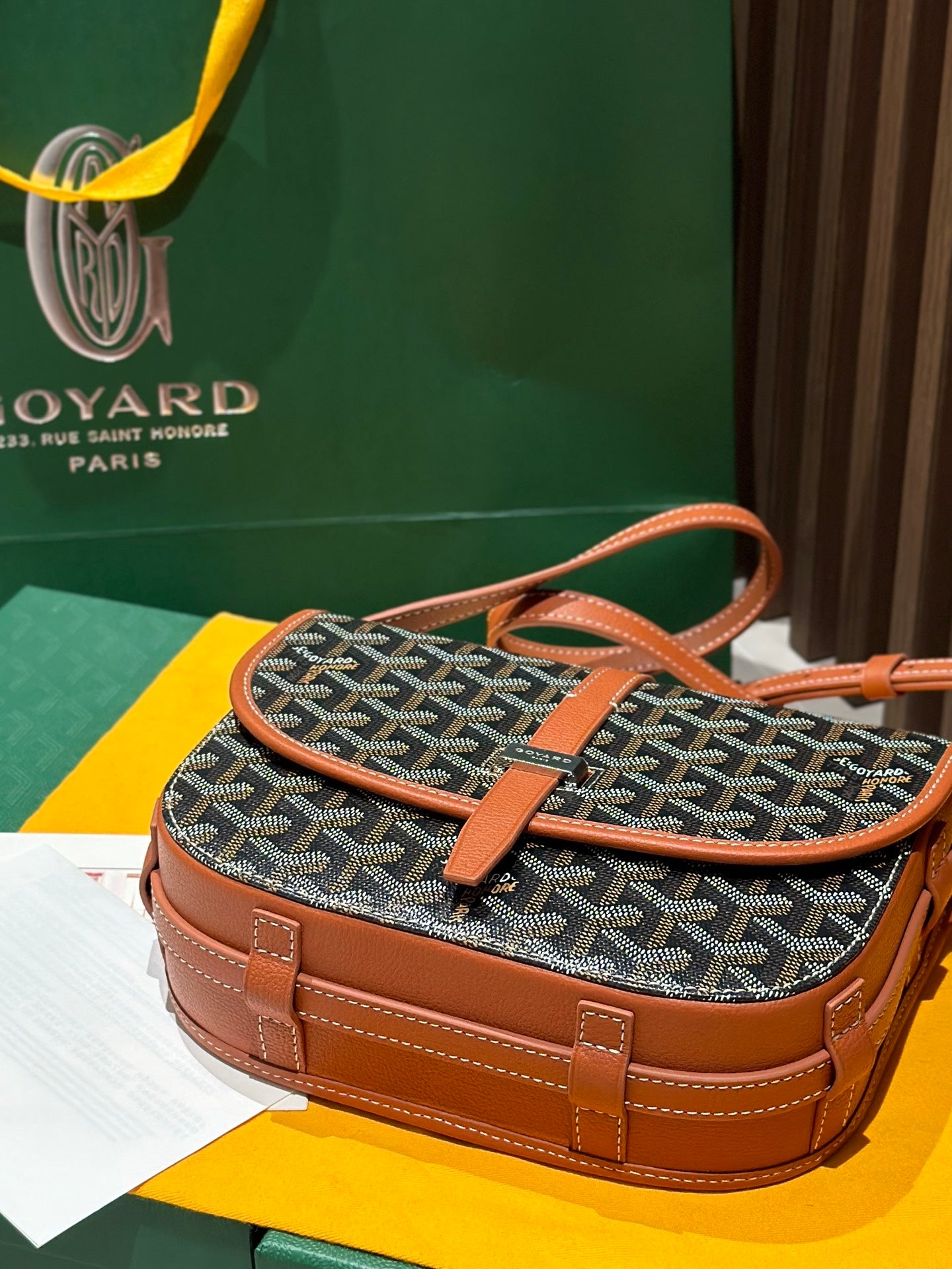 Goyard small shoulder bag with gray patterned body and tan handle, crossbody strap.