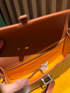 Goyard bag interior in tan leather with logo label and open top lining.