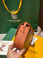 Goyard bag back panel in tan leather with small square clasp and strap loop.