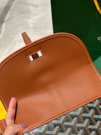 Goyard tan leather flap with small metal clasp and edge stitching.