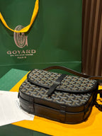 Goyard crossbody bag on display, patterned canvas top flap with black leather front