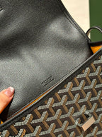 Goyard crossbody bag close-up of smooth black leather panel and patterned strap edge