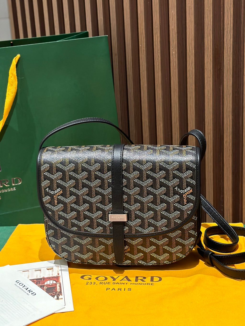 Goyard crossbody bag with patterned canvas, black leather trim, and top flap closure