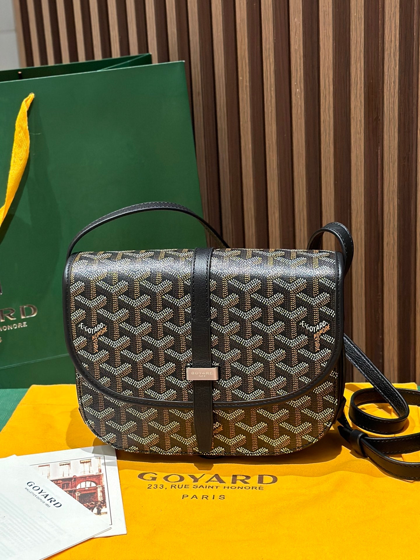 Goyard crossbody bag with patterned canvas, black leather trim, and top flap closure