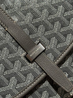 Goyard bag close-up of logo tag on patterned flap strap