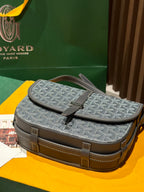 Goyard satchel-style bag with top flap, monogram pattern, and structured brown trim