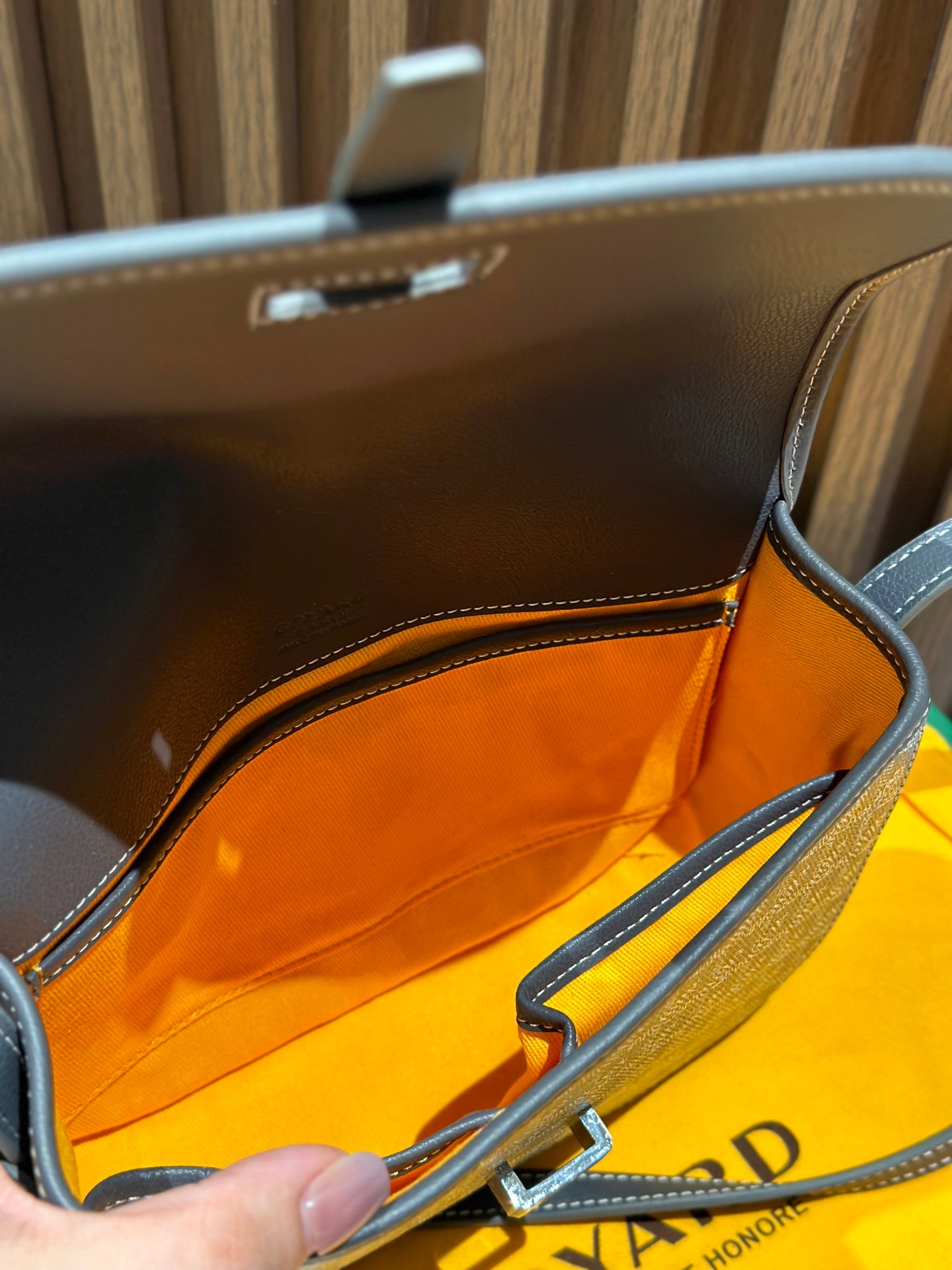 Goyard bag interior view with orange lining and open top flap