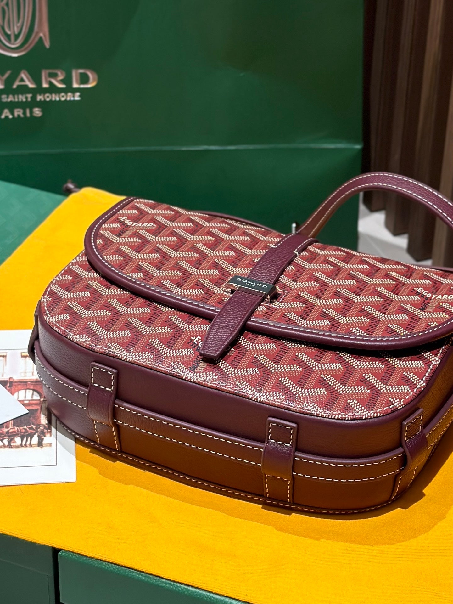 Goyard messenger bag with red monogram canvas, maroon flap and front buckle detail